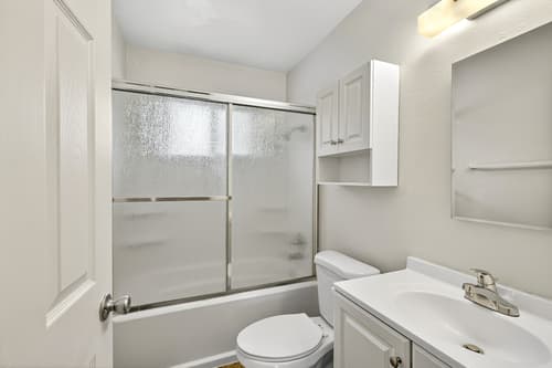 Updated bathroom with glass shower door and white vanity
