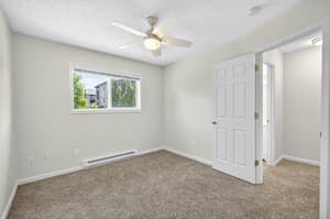 Bedroom with ceiling fan, carpeted floor, and fresh paint at Lincoln Court in Fairview, Oregon