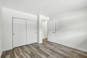 Bedroom with sliding closet doors, laminate flooring at Lincoln Court Townhomes, 230 Lincoln Street, Fairview, Oregon 97024