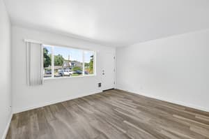 Living room with laminate flooring and fresh neutral walls at Lincoln Court in Fairview, Oregon